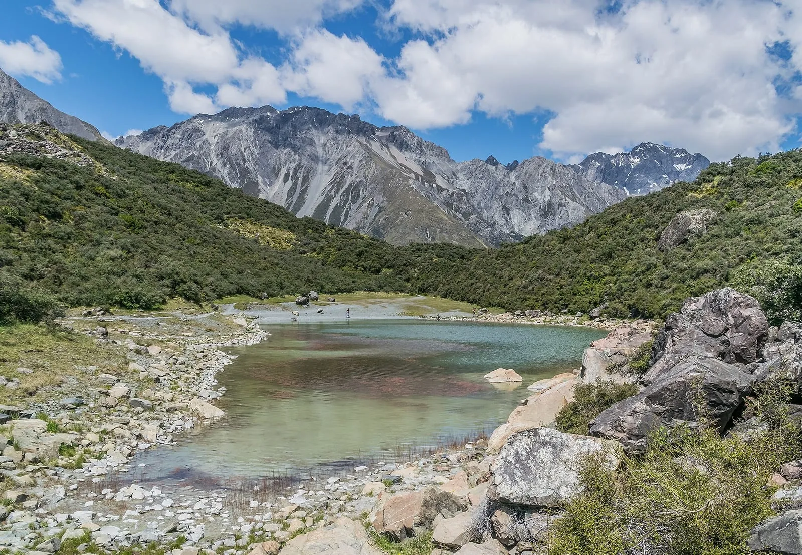 Blue Lake in Aoraki / Mount Cook National Park, New Zealand, with snow-capped mountains behind